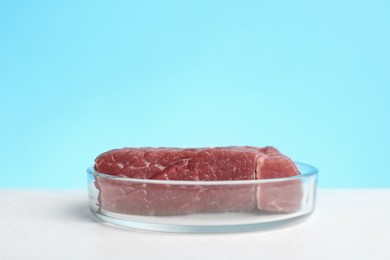 Photo of Lab grown meat in Petri dish on white table. Space for text