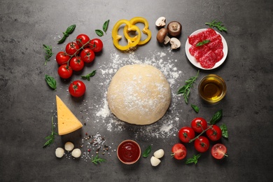 Photo of Flat lay composition with dough and fresh ingredients for pizza on grey table