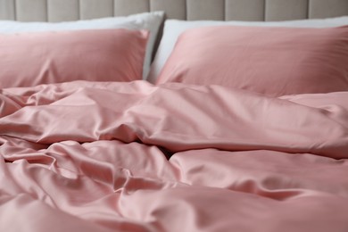 Photo of Bed with beautiful pink silk linens, closeup