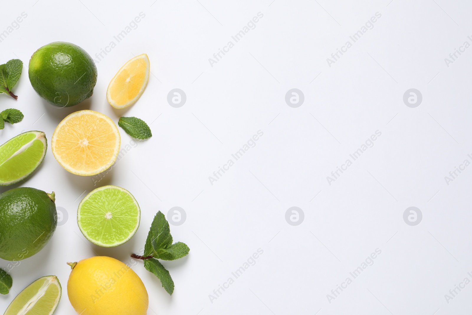 Photo of Fresh ripe lemons, limes and mint leaves on white background, top view