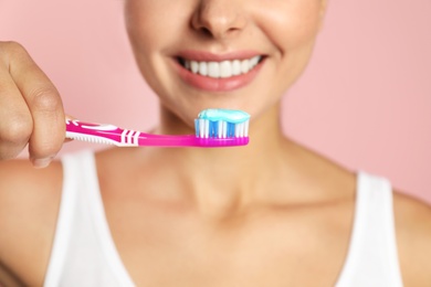 Photo of Young woman with toothbrush and paste on color background, closeup. Teeth care