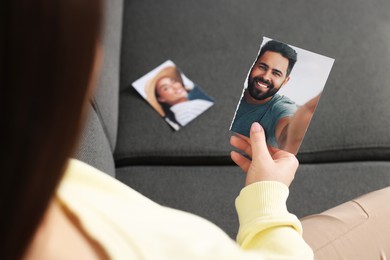 Photo of Woman holding part of photo on sofa, closeup. Divorce concept