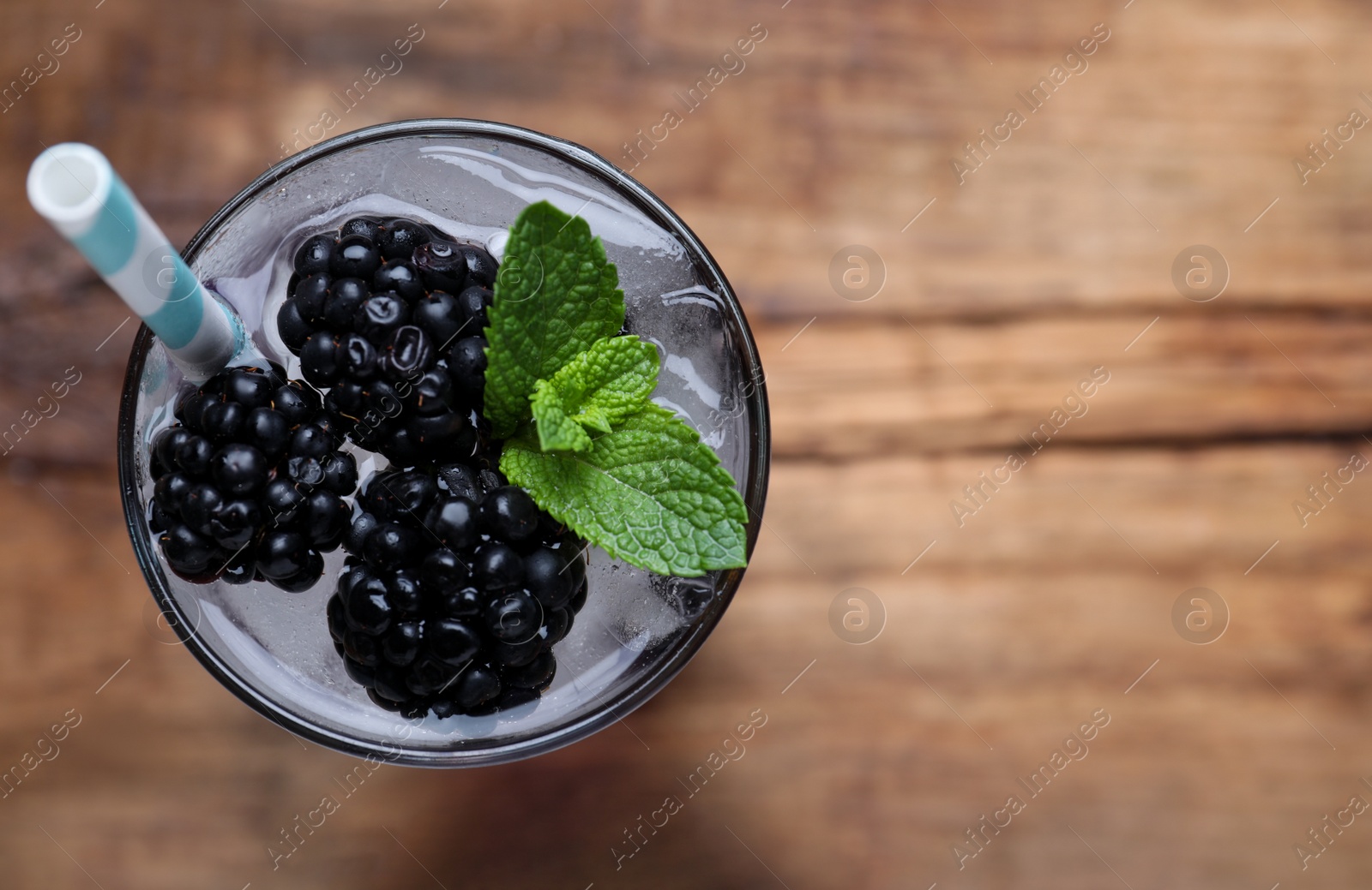 Photo of Delicious blackberry lemonade made with soda water on table, top view. Space for text