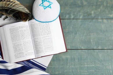 Photo of Flat lay composition with Rosh Hashanah holiday symbols on light blue wooden table. Space for text