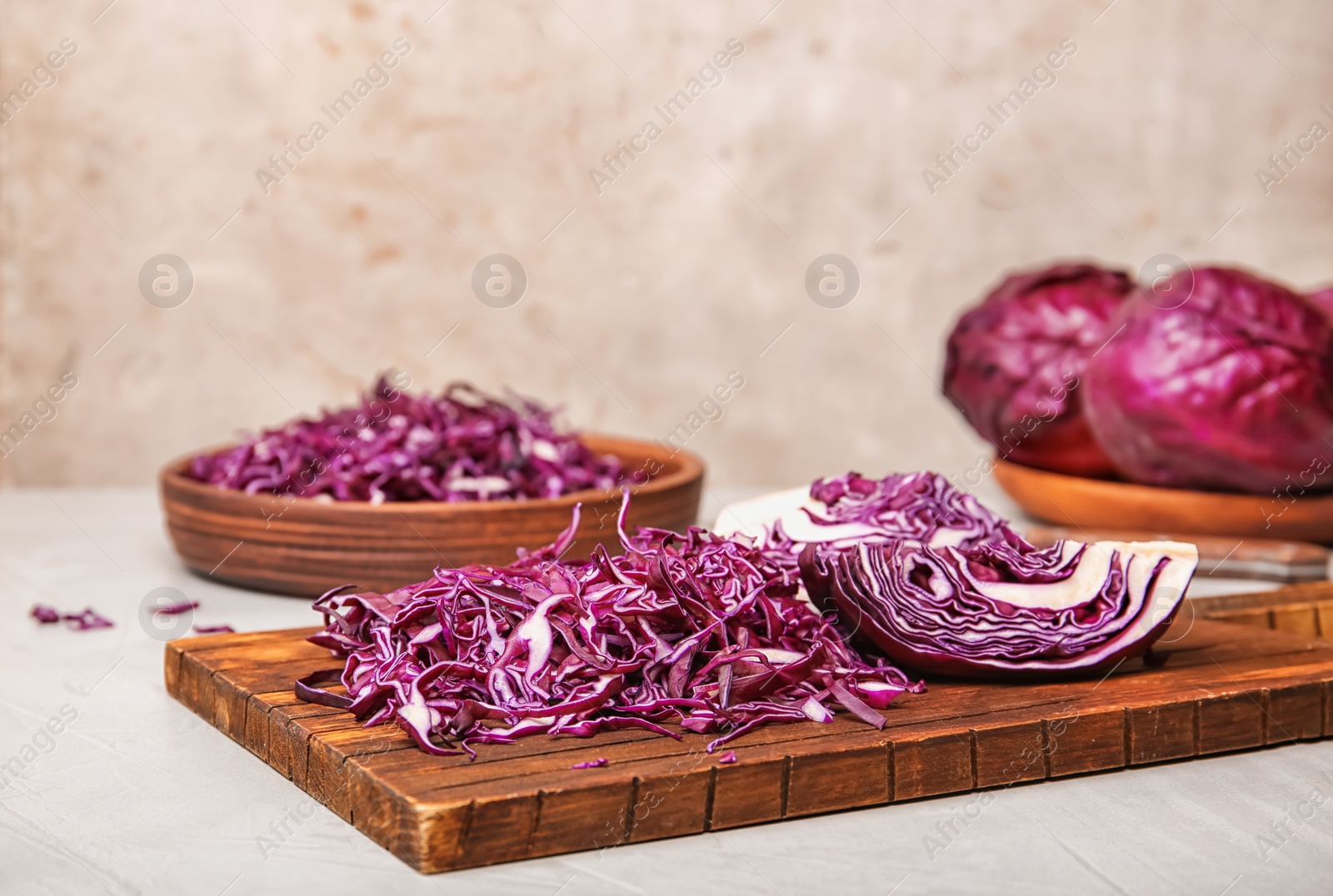 Photo of Wooden board with chopped purple cabbage on table