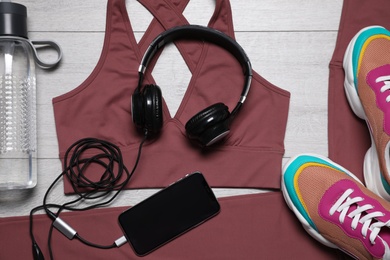 Photo of Stylish sportswear and equipment on light wooden background, flat lay