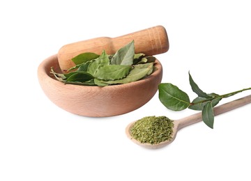 Wooden mortar and pestle with bay leaves on white background