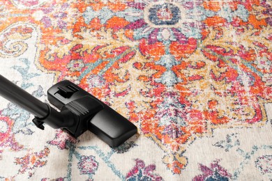 Photo of Hoovering carpet with modern vacuum cleaner. Space for text