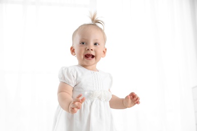 Adorable baby girl in cute clothes at home