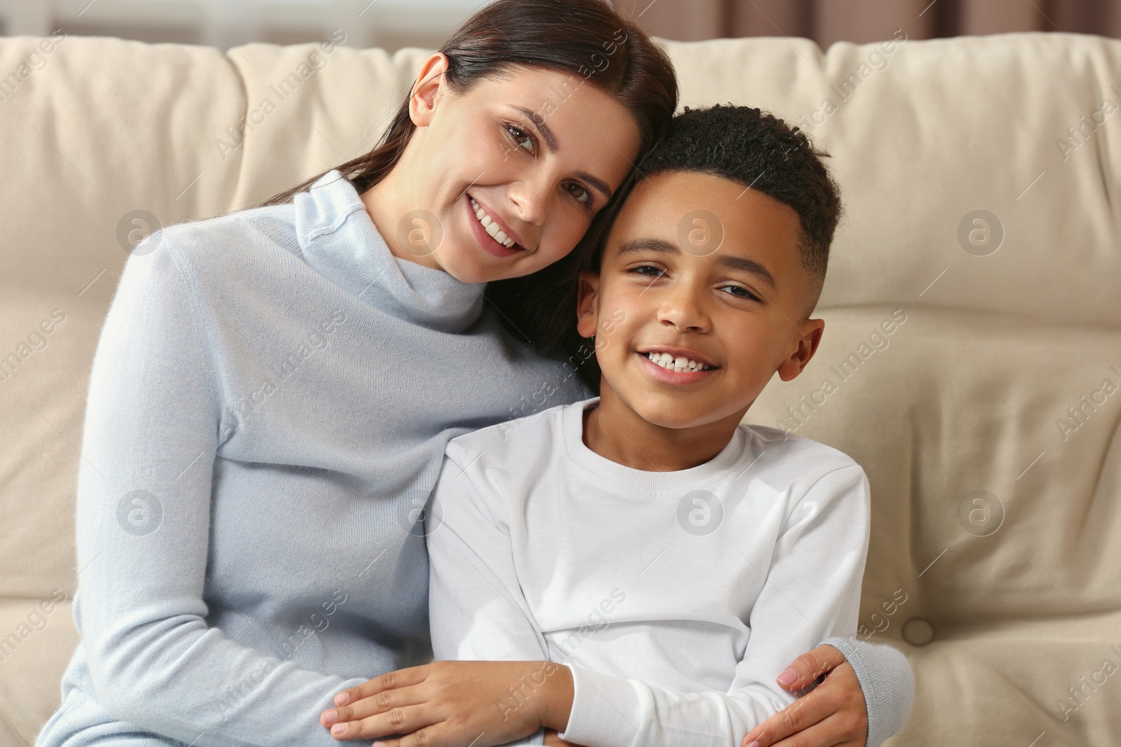 Photo of Mother with her African American son on sofa. International family