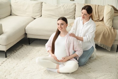 Doula taking care of pregnant woman at home. Preparation for child birth