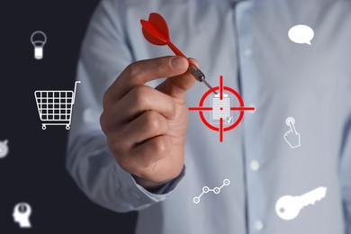 Image of Man aiming with dart to digital clipboard icon on dark background, closeup