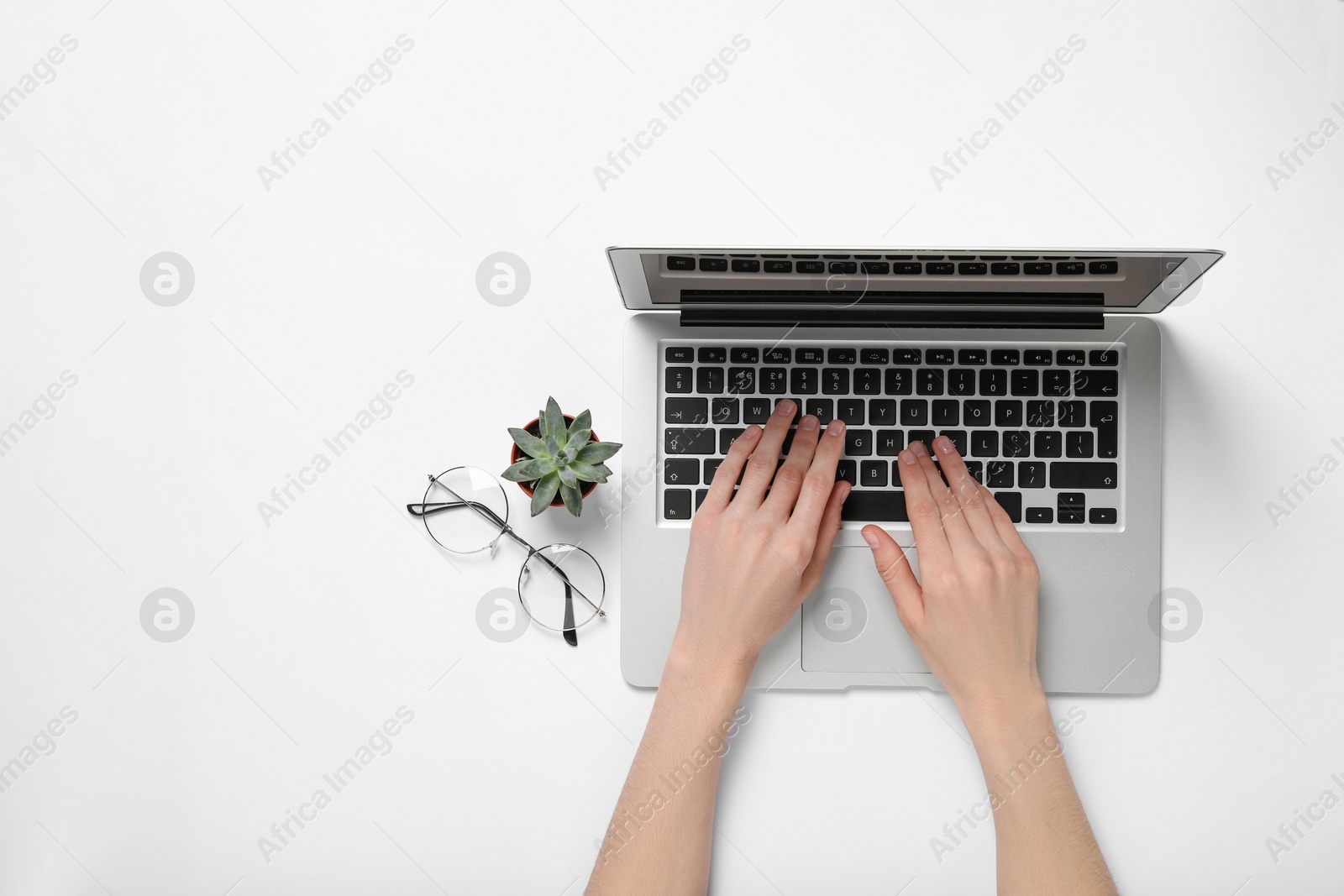 Photo of Woman using laptop at white table, top view. Space for text