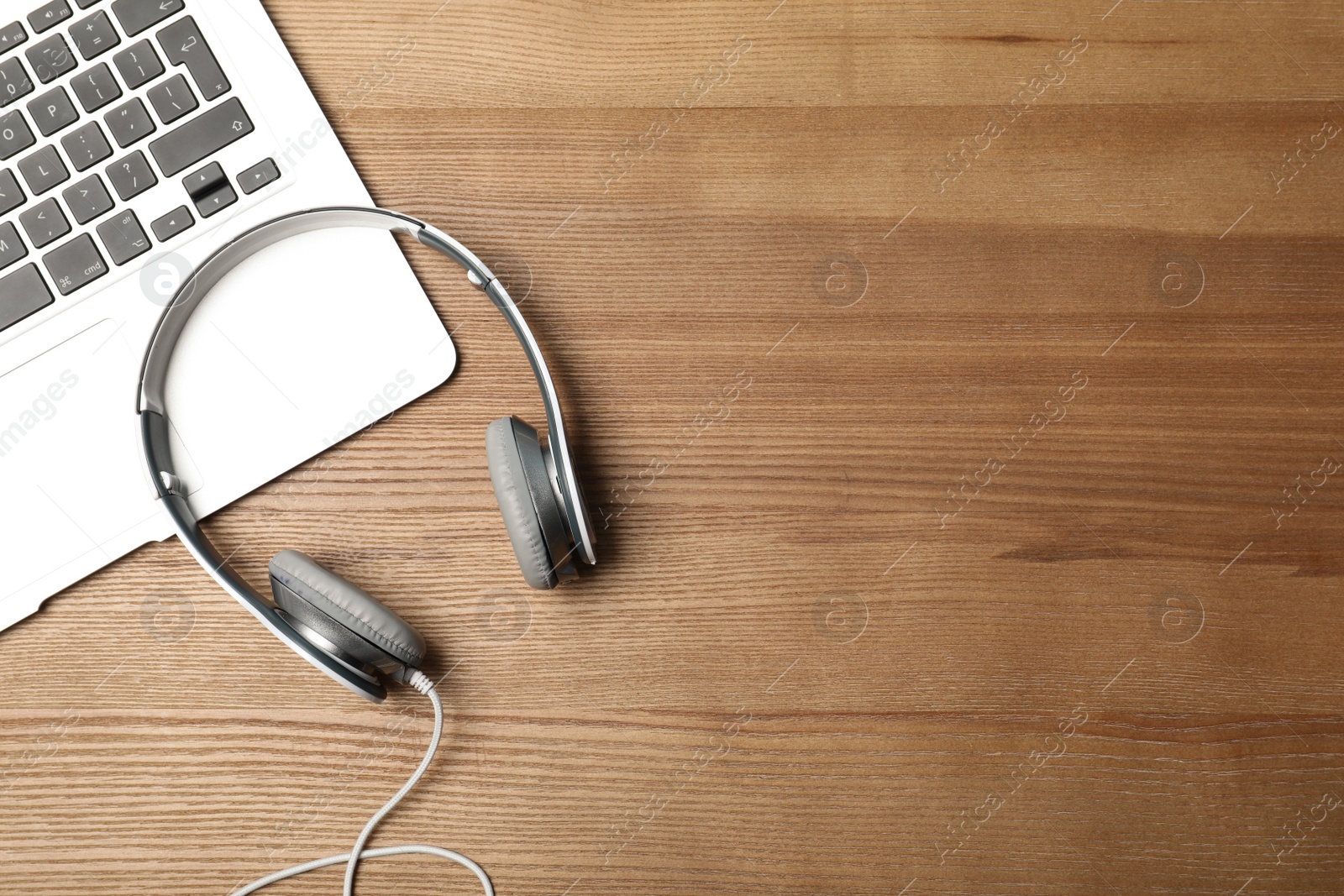 Photo of Flat lay composition with headphones, laptop and space for text on wooden background