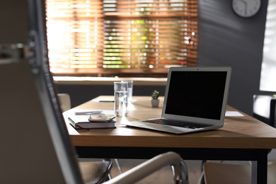 Photo of Laptop on wooden table in modern office