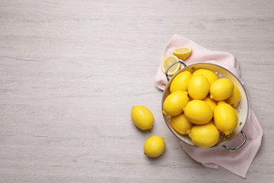 Photo of Many fresh ripe lemons on wooden table, flat lay. Space for text
