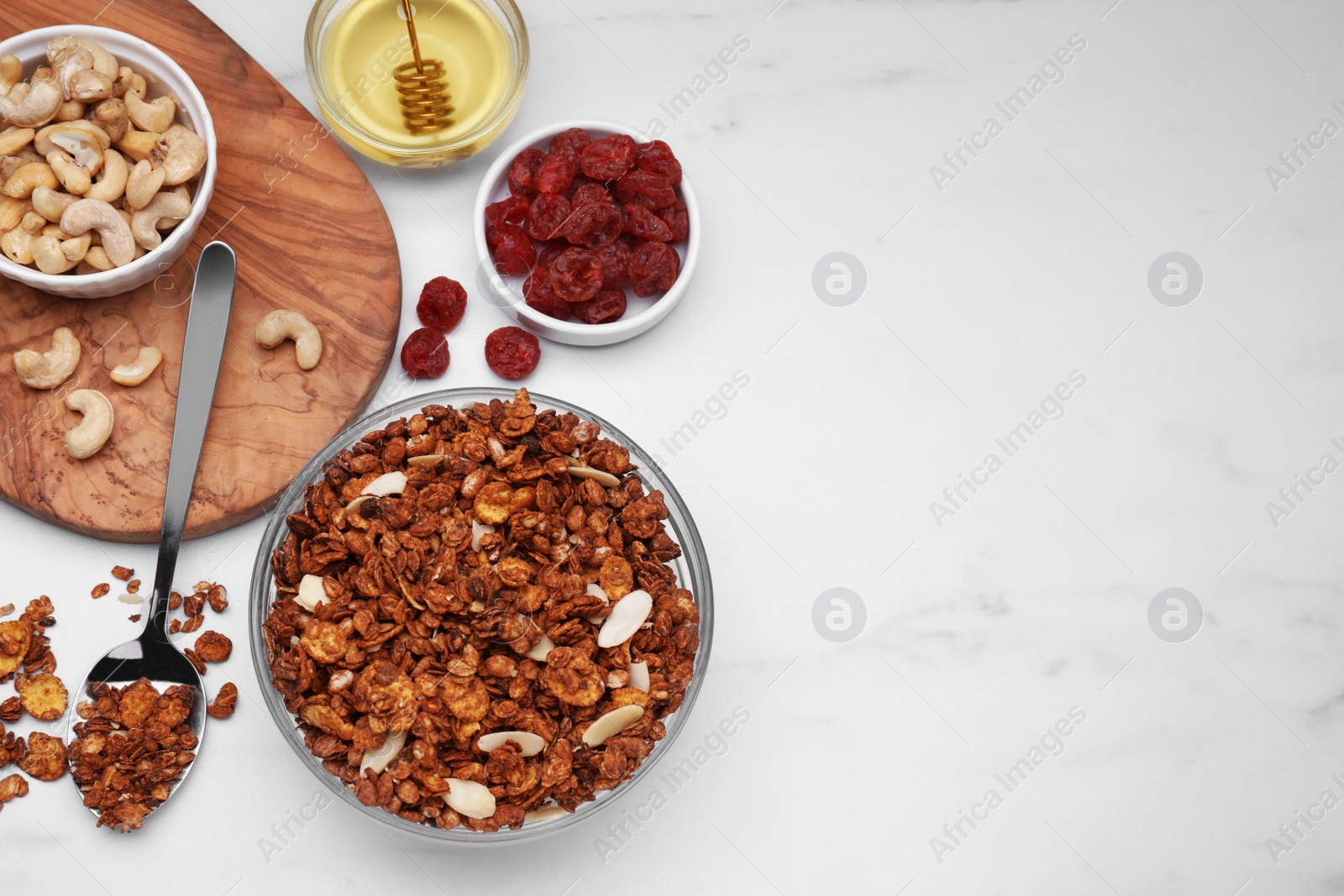 Photo of Tasty granola with nuts and dry fruits on white marble table, flat lay. Space for text