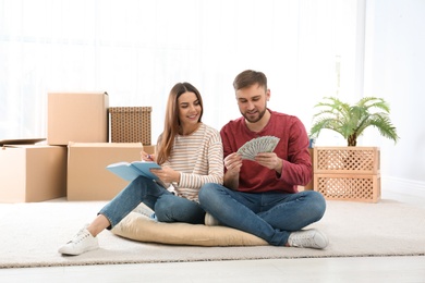 Beautiful young couple with money at home