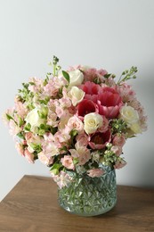 Beautiful bouquet of fresh flowers in vase on wooden table