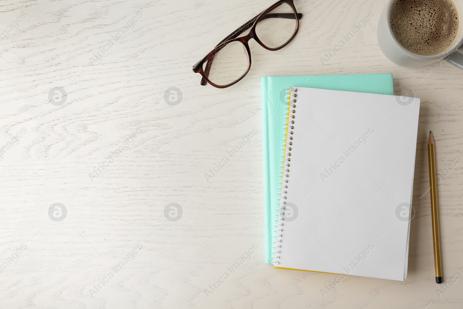 Photo of Flat lay composition with office stationery and cup of coffee on white wooden table. Space for design