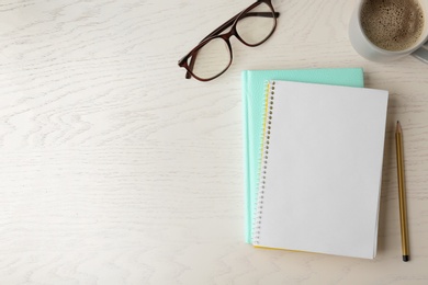 Photo of Flat lay composition with office stationery and cup of coffee on white wooden table. Space for design