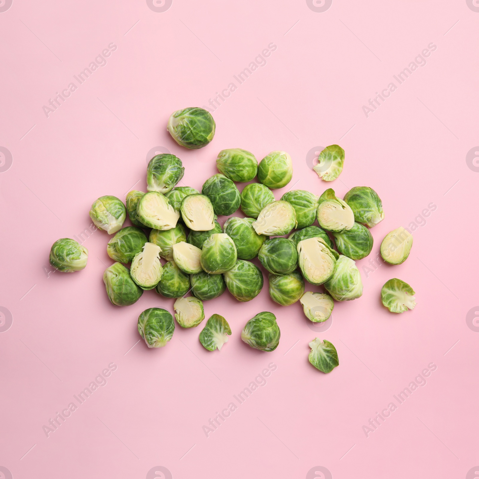 Photo of Fresh Brussels sprouts on pink background, flat lay