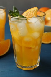 Photo of Delicious orange soda water on blue wooden table