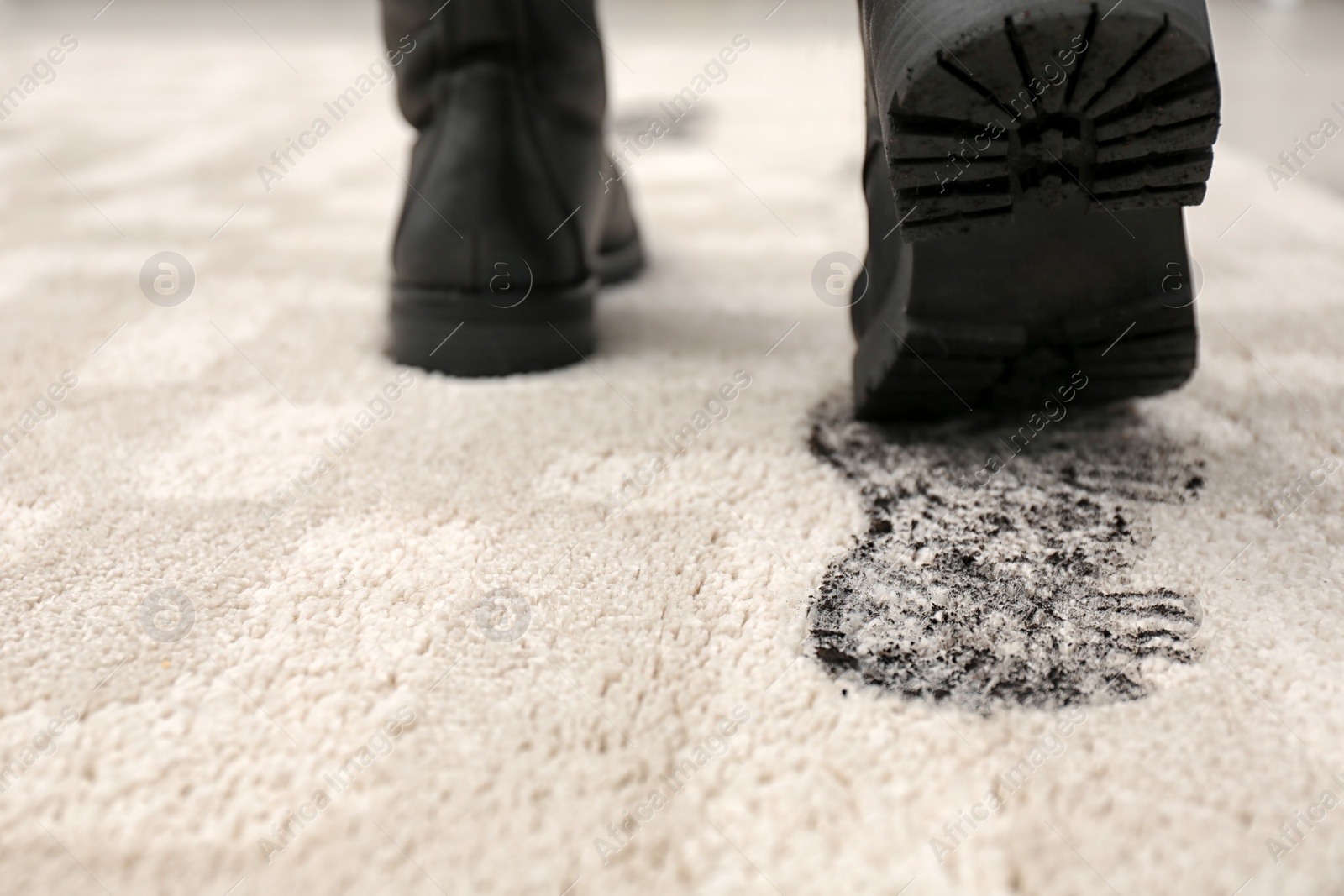 Photo of Person in dirty shoes leaving muddy footprints on carpet