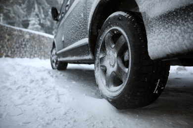 Modern car covered in snow outdoors on winter day, closeup