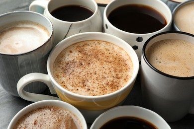 Many cups of different coffees on table, closeup