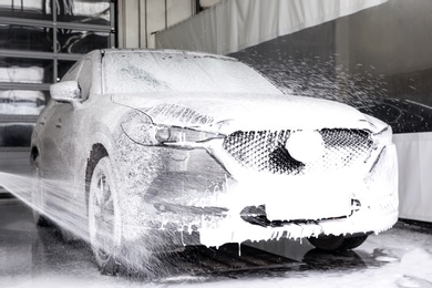 Photo of Cleaning automobile with high pressure water jet at car wash