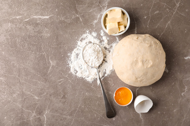 Flat lay composition with dough on marble table, space for text. Cooking pastries