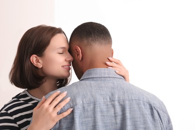 Dating agency. Woman hugging her boyfriend on white background