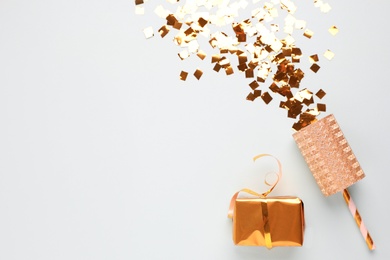 Photo of Flat lay composition with golden confetti and box on light background, space for text