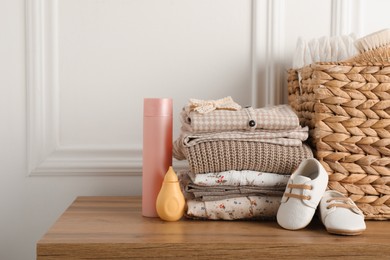 Photo of Baby clothes, shoes and accessories on wooden table