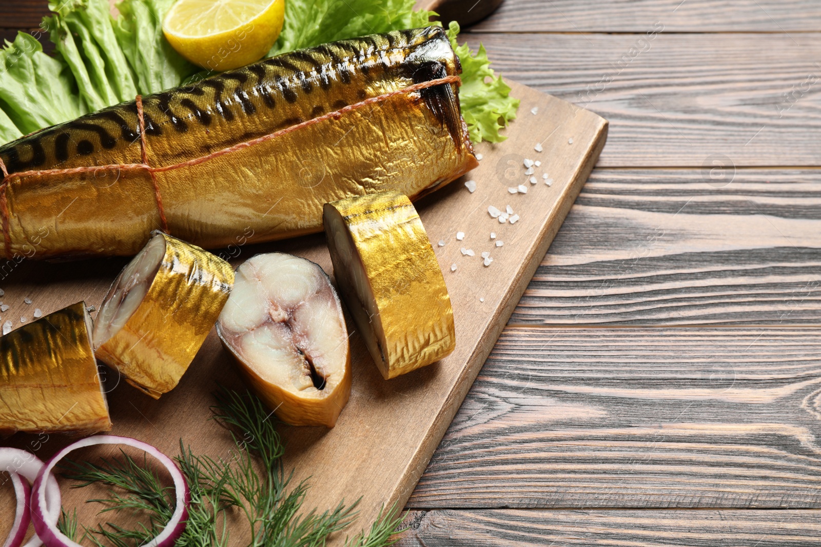 Photo of Tasty smoked fish on wooden table, closeup