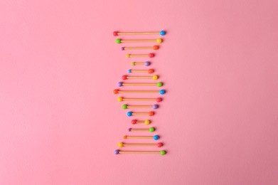 Model of DNA molecular chain on pink background, top view