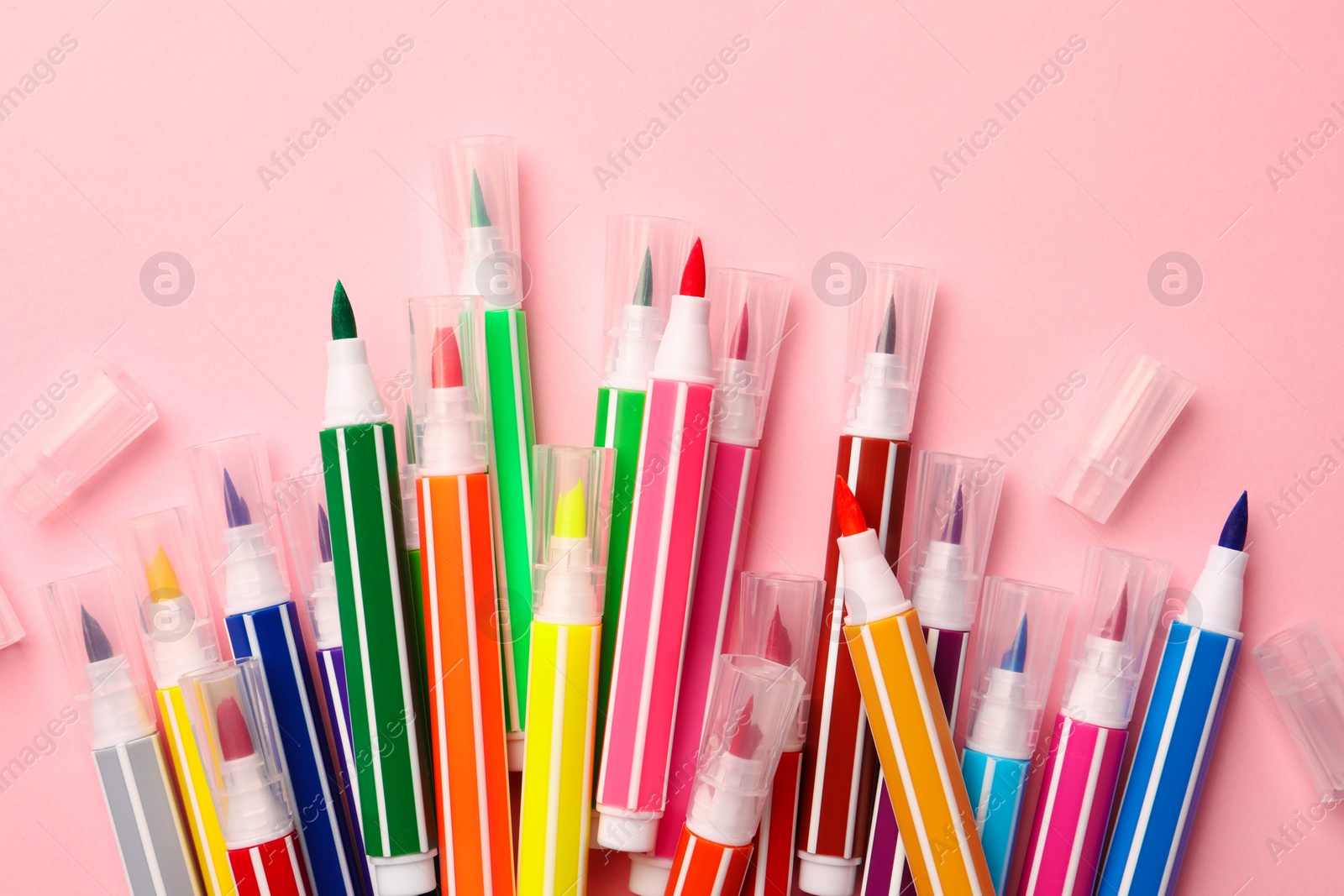 Photo of Many bright markers on pink background, flat lay