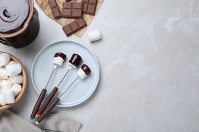 Photo of Tasty marshmallows dipped into chocolate on light grey marble table, flat lay. Space for text