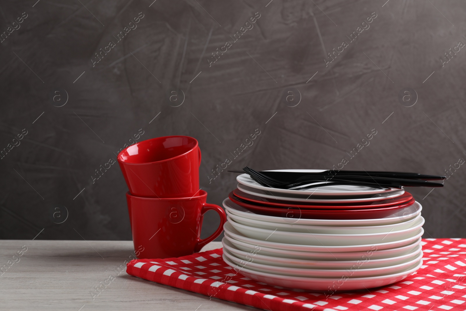 Photo of Set of clean dishware and cutlery on light wooden table