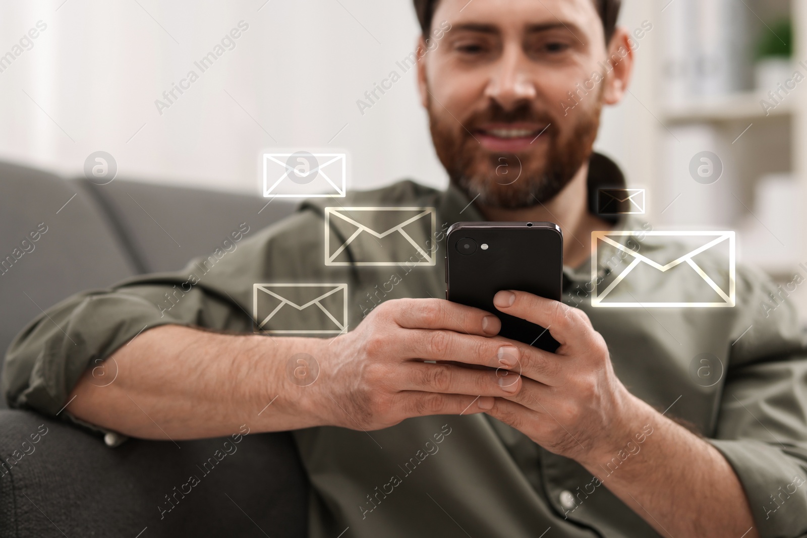 Image of Smiling man with smartphone chatting indoors. Many illustrations of envelope as incoming messages around device