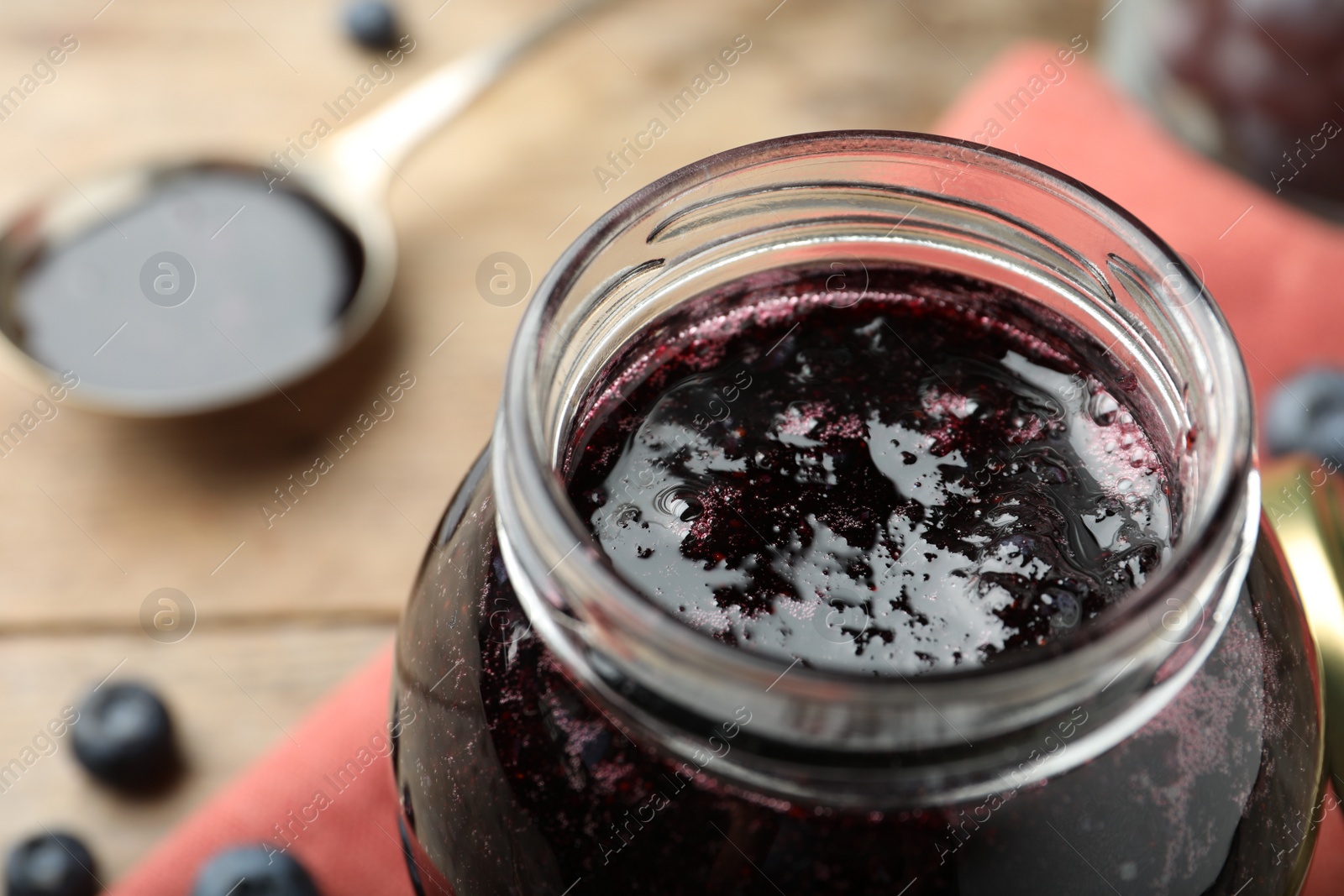 Photo of Jar of delicious blueberry jam, closeup view