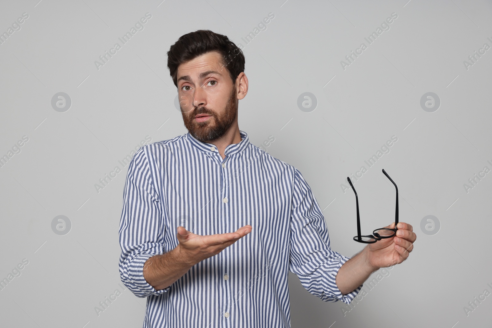 Photo of Man suffering from eyestrain on light grey background
