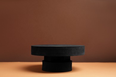 Photo of Black stand on brown background, space for text. Stylish presentation for product