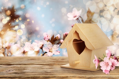 Image of Beautiful bird house on wooden table outdoors, space for text