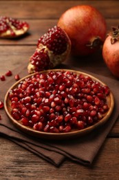 Ripe juicy pomegranates and grains on wooden table