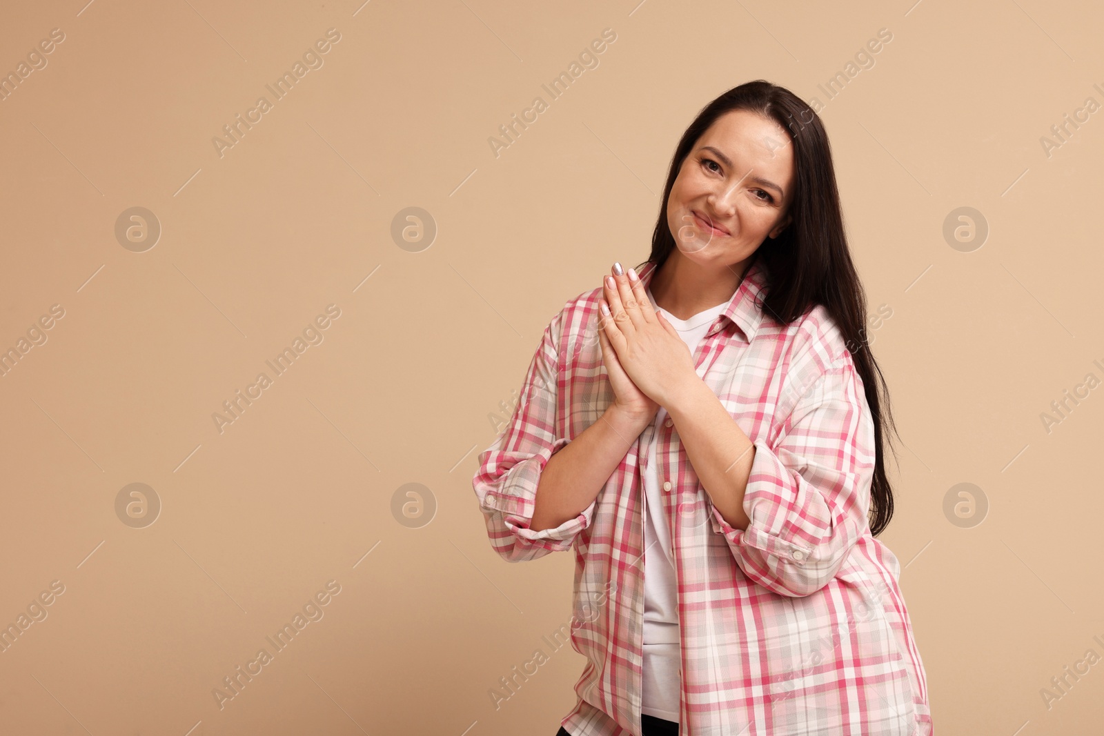 Photo of Beautiful overweight woman with charming smile on beige background. Space for text