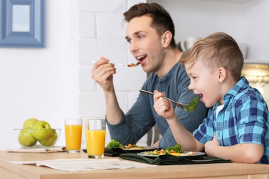 Photo of Dad and his son having breakfast in kitchen