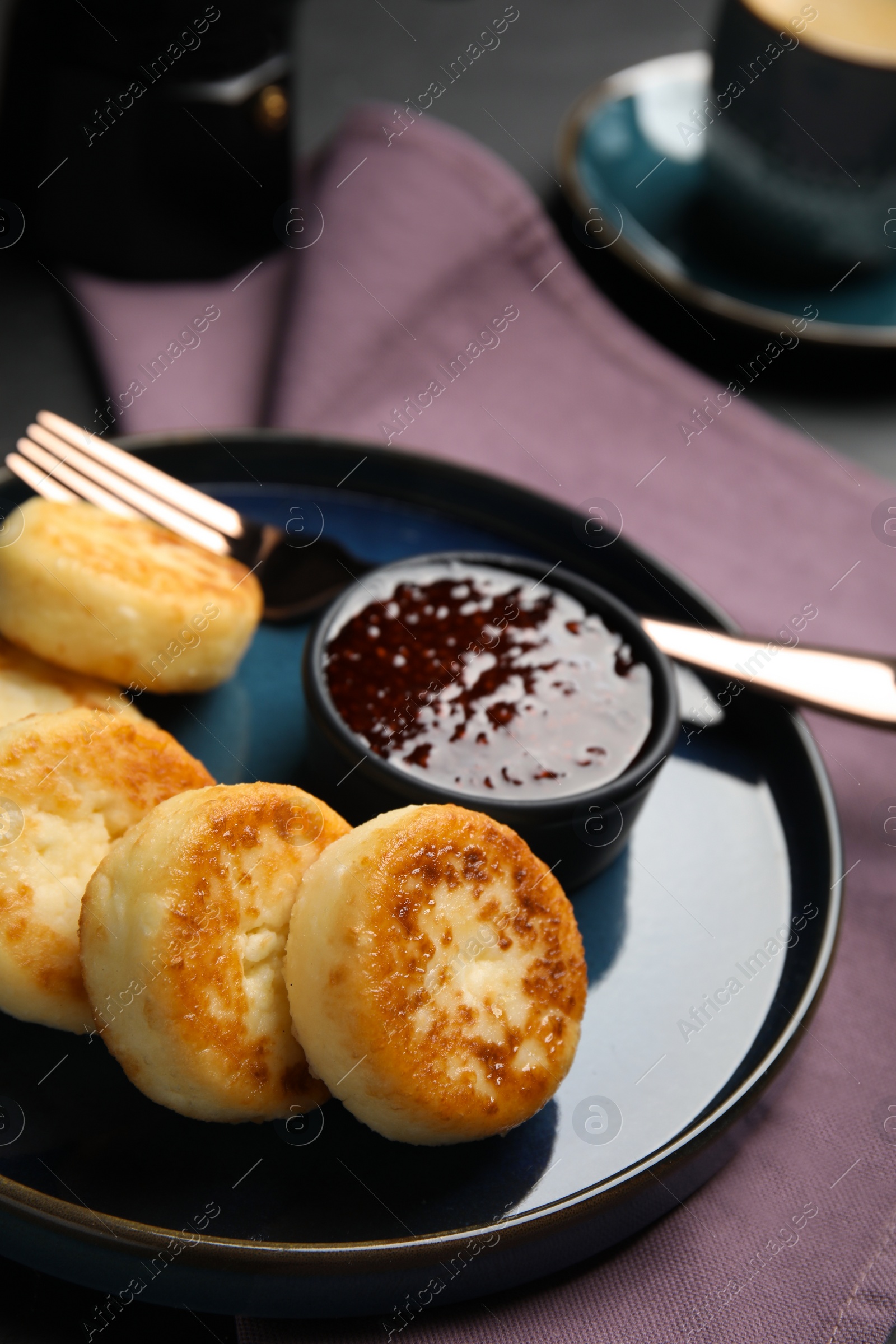 Photo of Delicious cottage cheese pancakes with jam on table