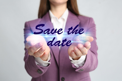 Young woman against light grey background, focus on hands. Save the date 